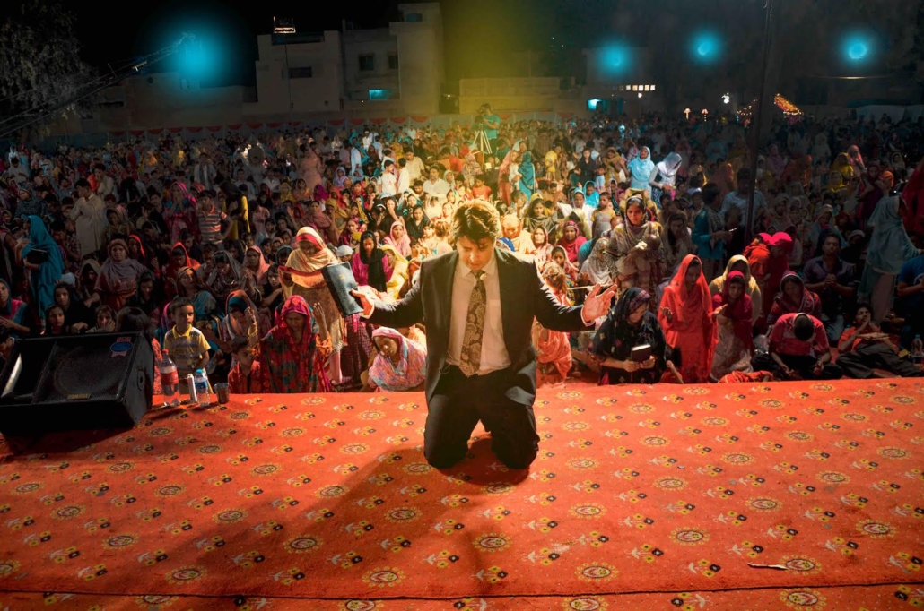 Rev. Dr. Naeem Nasir, Church Planting in Pakistan: kneeling in prayer on stage